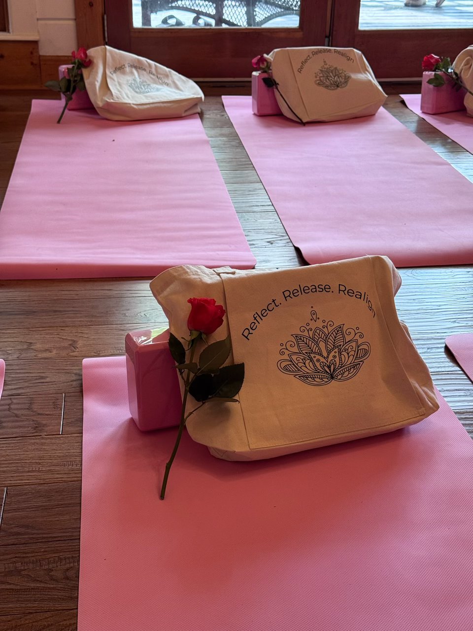 Reflect Release Realign tote bag with a single red rose resting on a pink mat